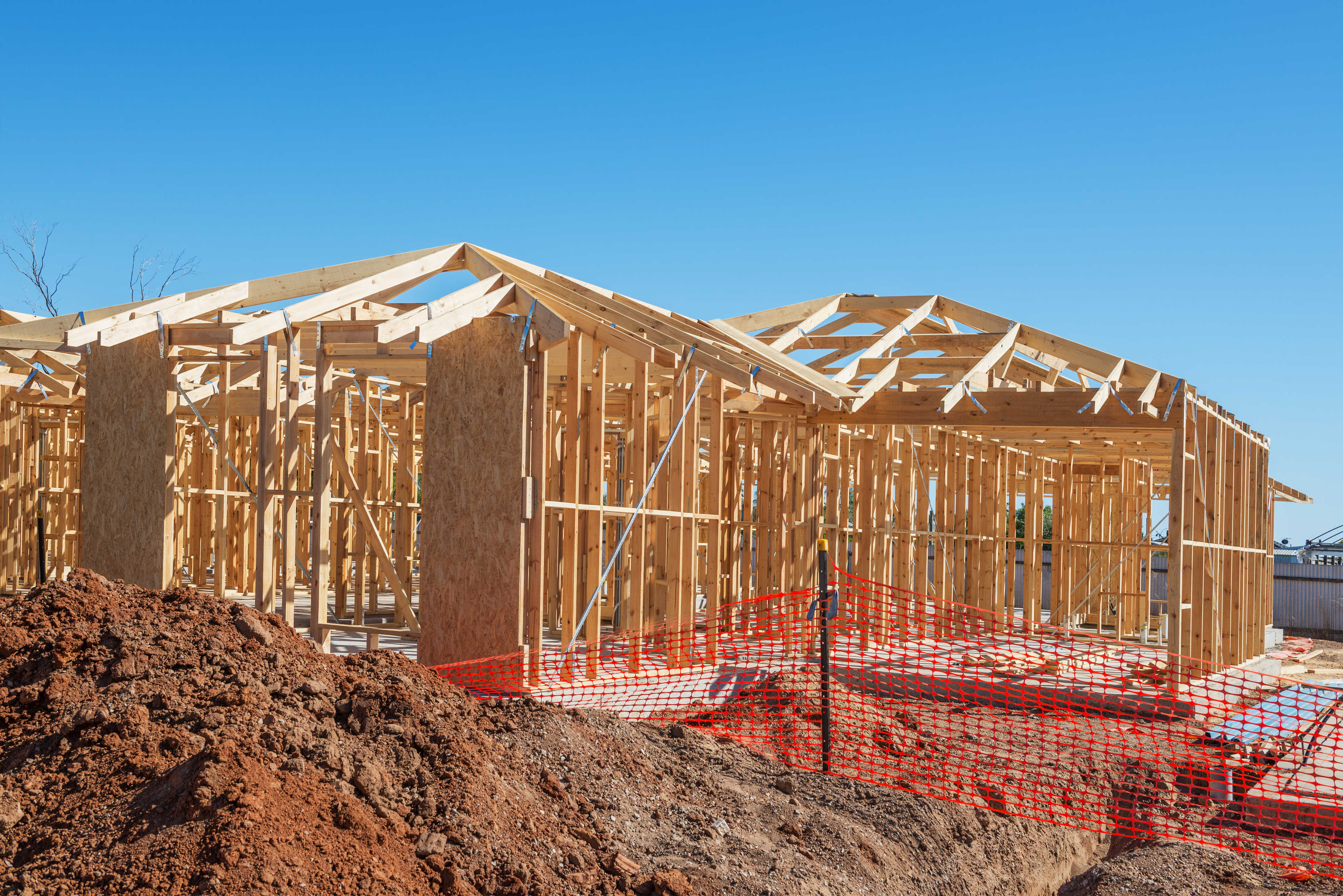 Residential construction site with workers and framing — new investment property build in progress (stock photo)